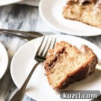 a slice of sour cream coffee cake on a white plate
