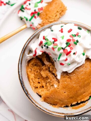 gingerbread mug cake with scoop taken out and spoon sitting on the side