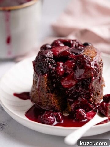 chocolate berry mug cake on plate with spoon on the side