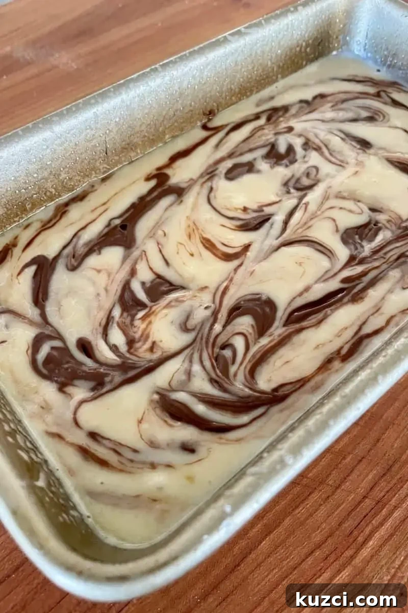 batter in a loaf pan with swirls of nutella throughout.