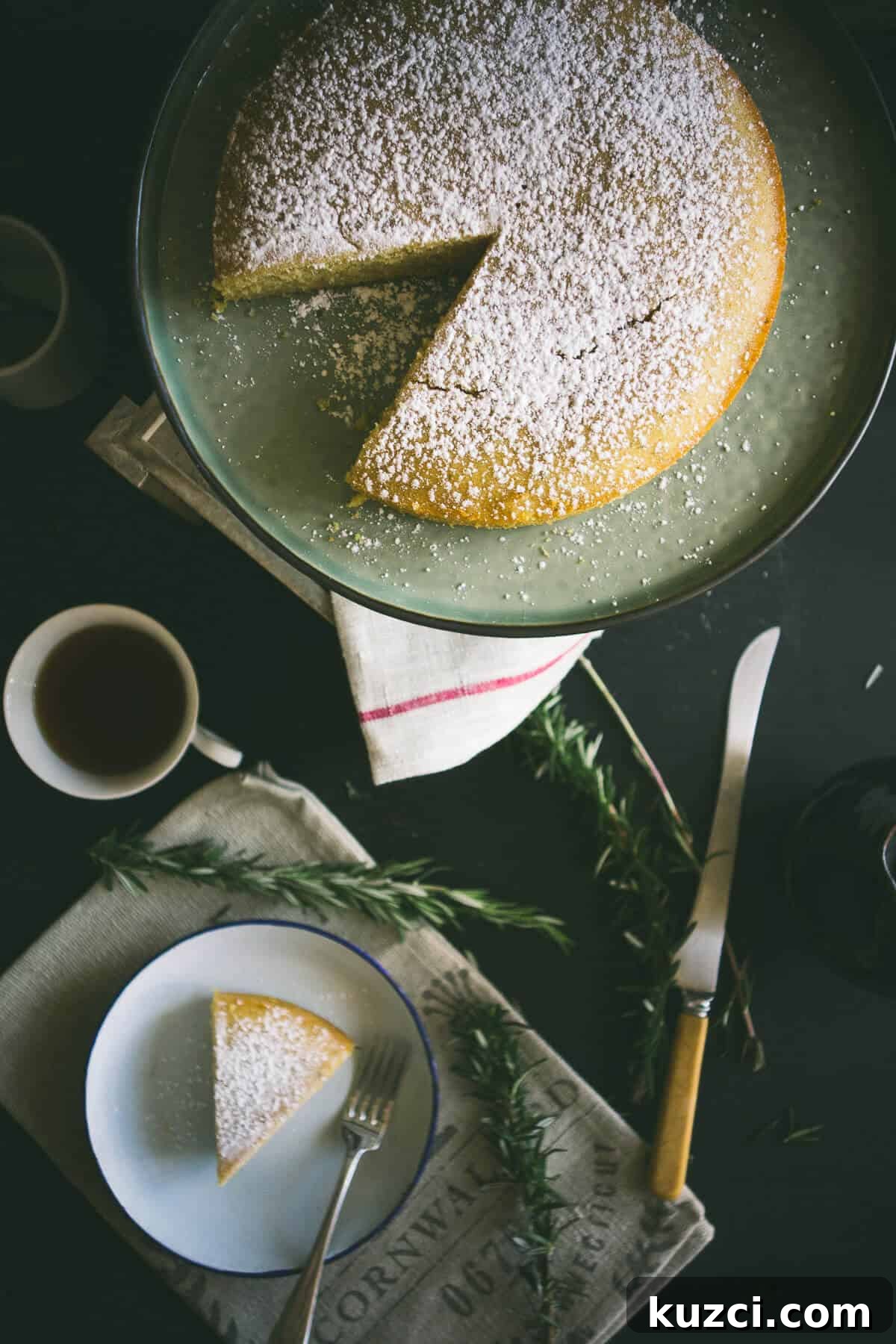 a birds eye view of a sliced cake with a cup of tea and a knife next to it