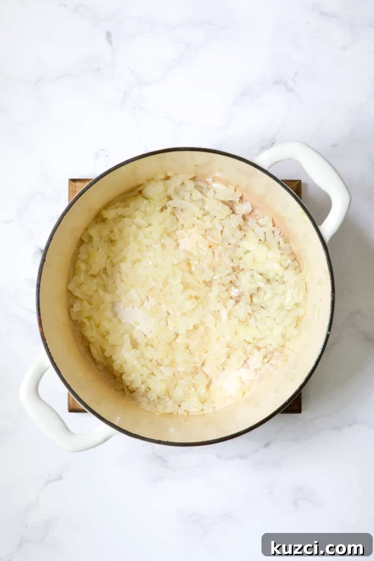 Creamy Shrimp and Corn Soup Recipe 5 Cooked onion in white Dutch oven.