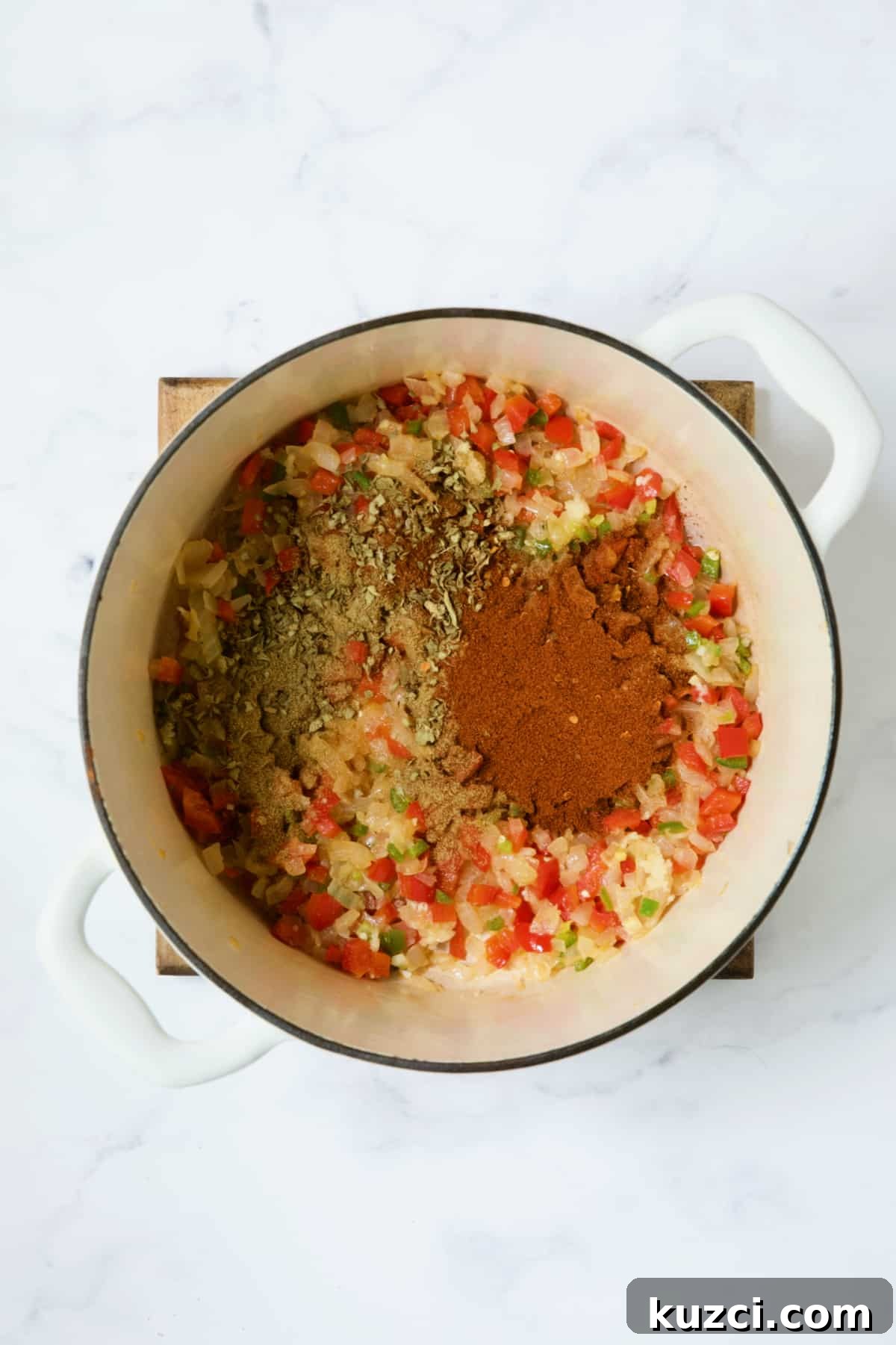 Creamy Shrimp and Corn Soup Recipe 7 Spices added to vegetables in white Dutch oven.