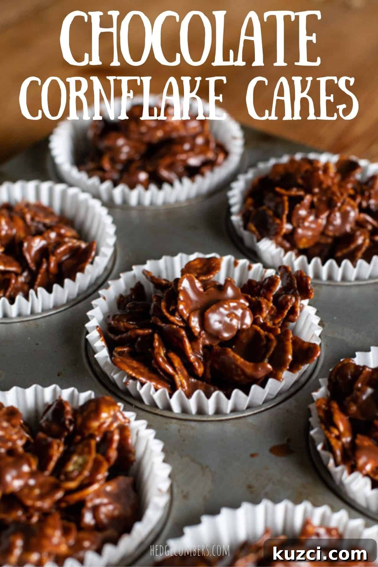 No-Bake Chocolate Cornflake Cakes Recipe 2 chocolate covered cornflake cakes in white paper cases in a metal baking tray