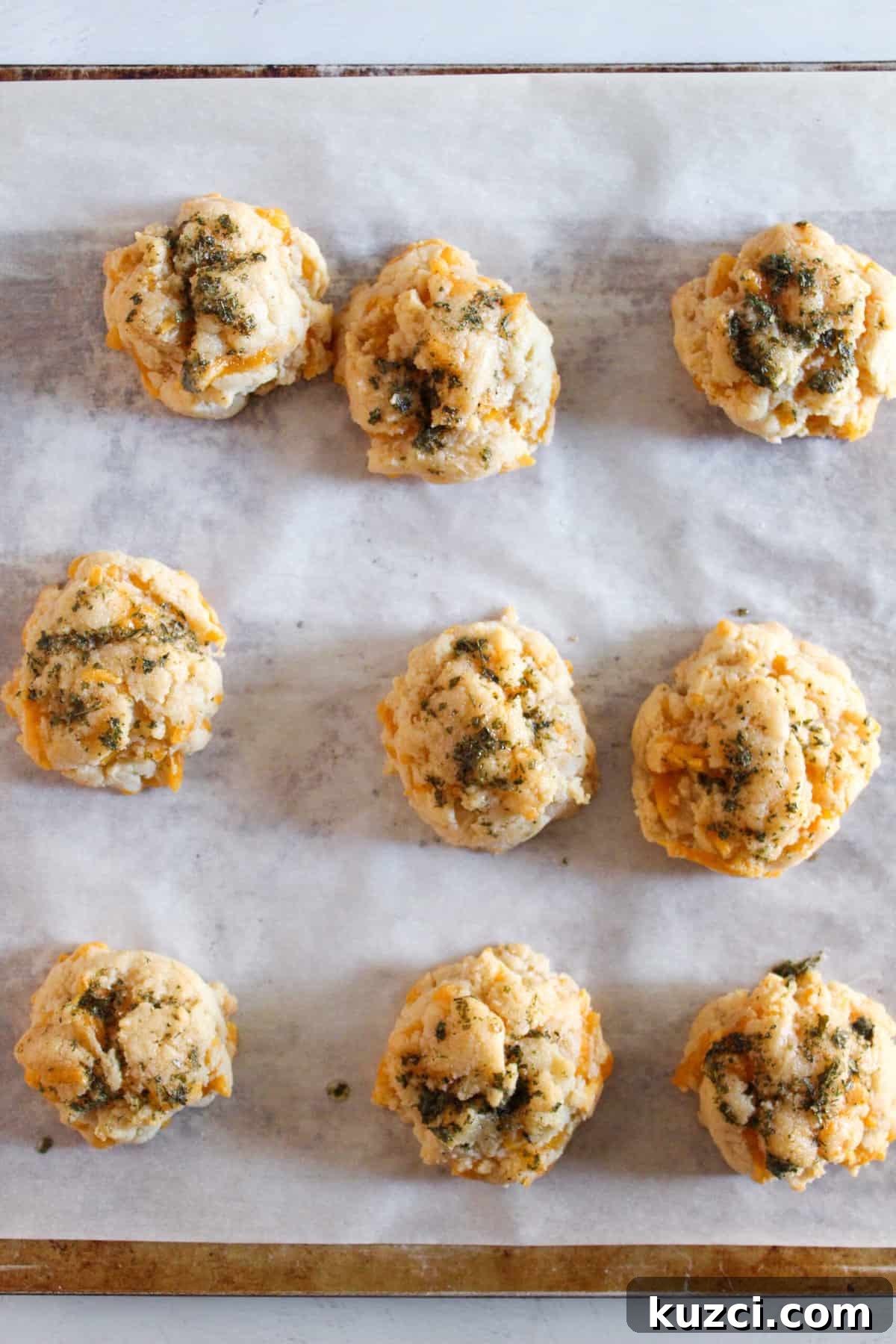 Gluten Free Dairy Free Cheddar Bay Biscuits Copycat 11 gluten free cheddar bay biscuits baked, sitting on a cookie sheet.