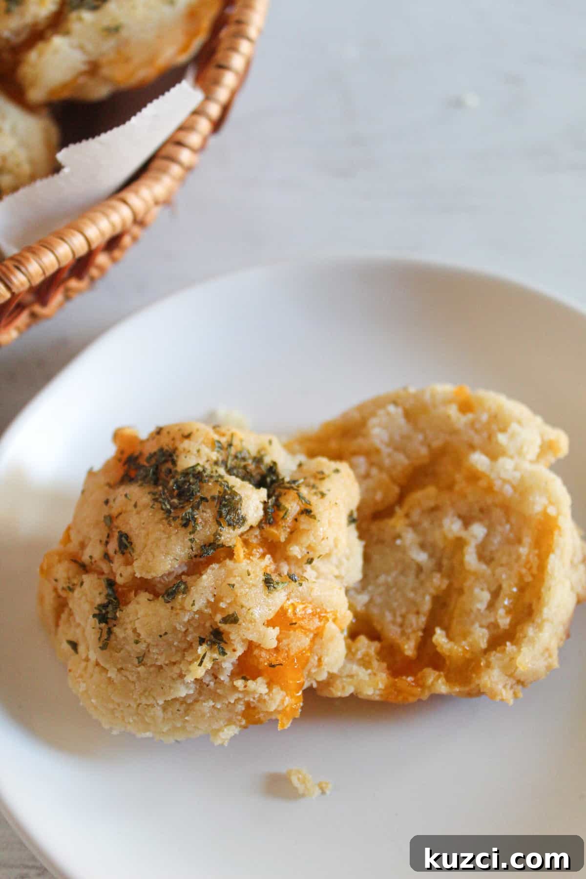 Gluten Free Dairy Free Cheddar Bay Biscuits Copycat 3 sliced gluten free cheddar bay biscuits on a white plate.