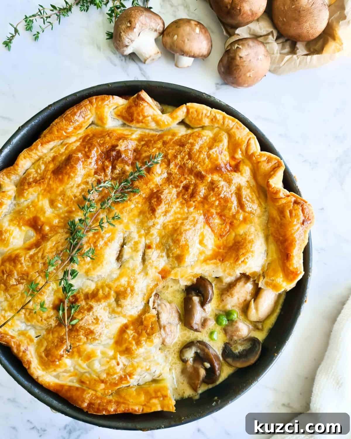 Creamy Chicken and Mushroom Pie Recipe with Flaky Crust 2 Chicken and mushroom pot pie with a portion of the pastry lifted showing creamy filling.