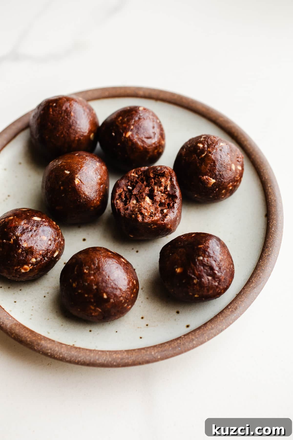 Chocolate Almond Butter Protein Balls Recipe 8 Chocolate protein balls on a plate.