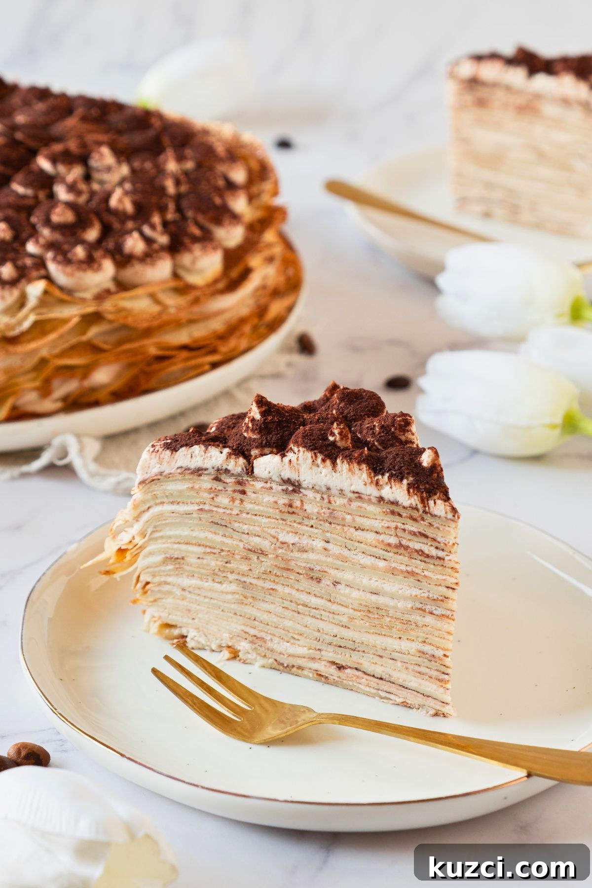 Classic French Crepe Cake (Mille Crepes) Recipe 2 Golden light and fluffy slice of cake made from layers of thin crepes, served on a white plate.