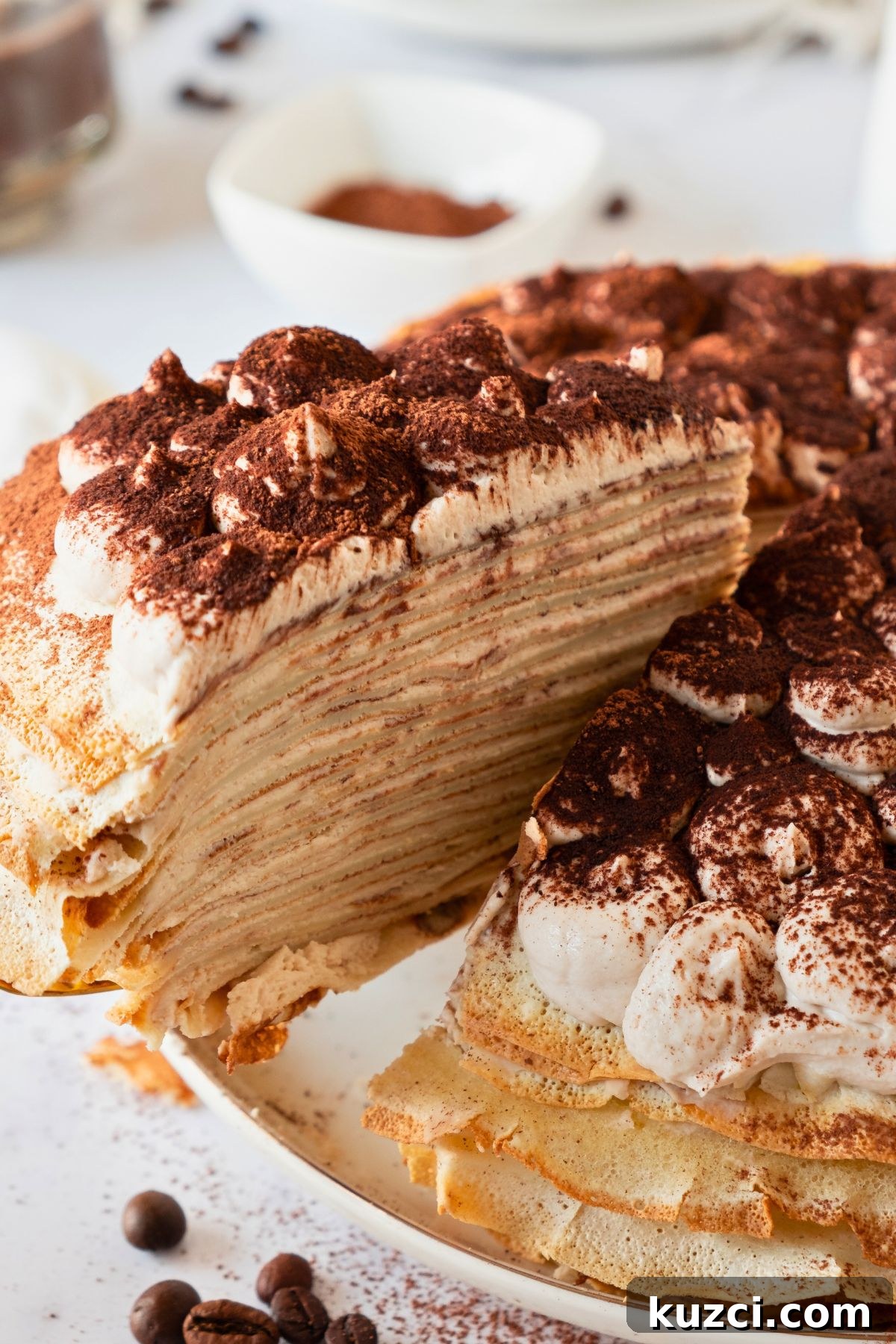 Classic French Crepe Cake (Mille Crepes) Recipe 8 Slice of crepe cake being lifted off of cake plate showing the layers.