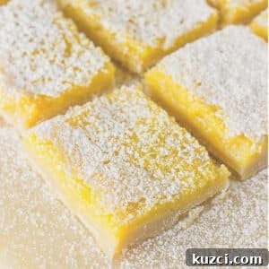 Zesty Lemon Bars Recipe with Buttery Shortbread Crust 13 Cut lemon bars sprinkled with powdered sugar and cut into squares.