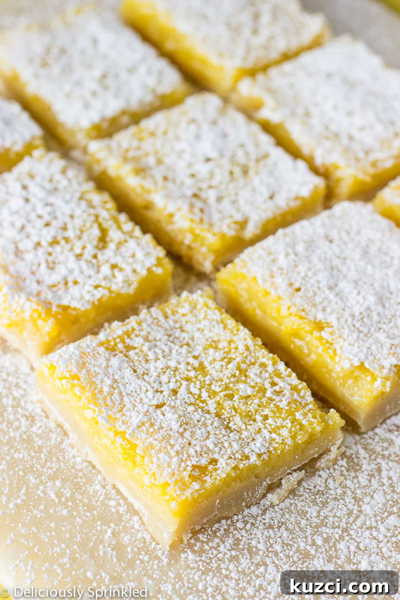 Zesty Lemon Bars Recipe with Buttery Shortbread Crust 3 Cut lemon bars sprinkled with powdered sugar and cut into squares.