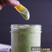 Avocado Lime Crema Recipe 16 Avocado lime crema sauce with chip dipping into the jar.
