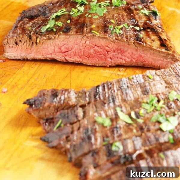 Avocado Lime Crema Recipe 8 grilled flank steak on wood cutting board sliced into strips medium rare, veggies in background