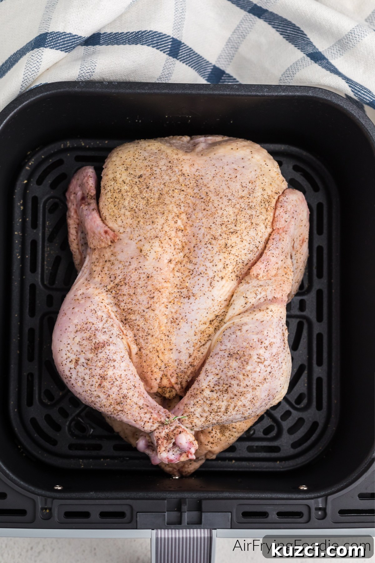 Crispy Whole Chicken in the Air Fryer 6 Seasoned whole chicken in air fryer basket.