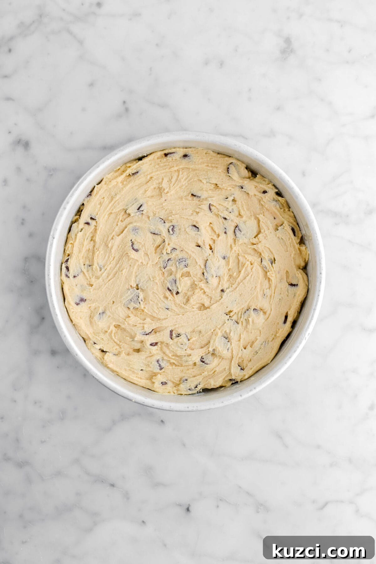 Chocolate Chip Cookie Cake with Chocolate Buttercream 19 chocolate chip cookie dough spread in round cake pan.