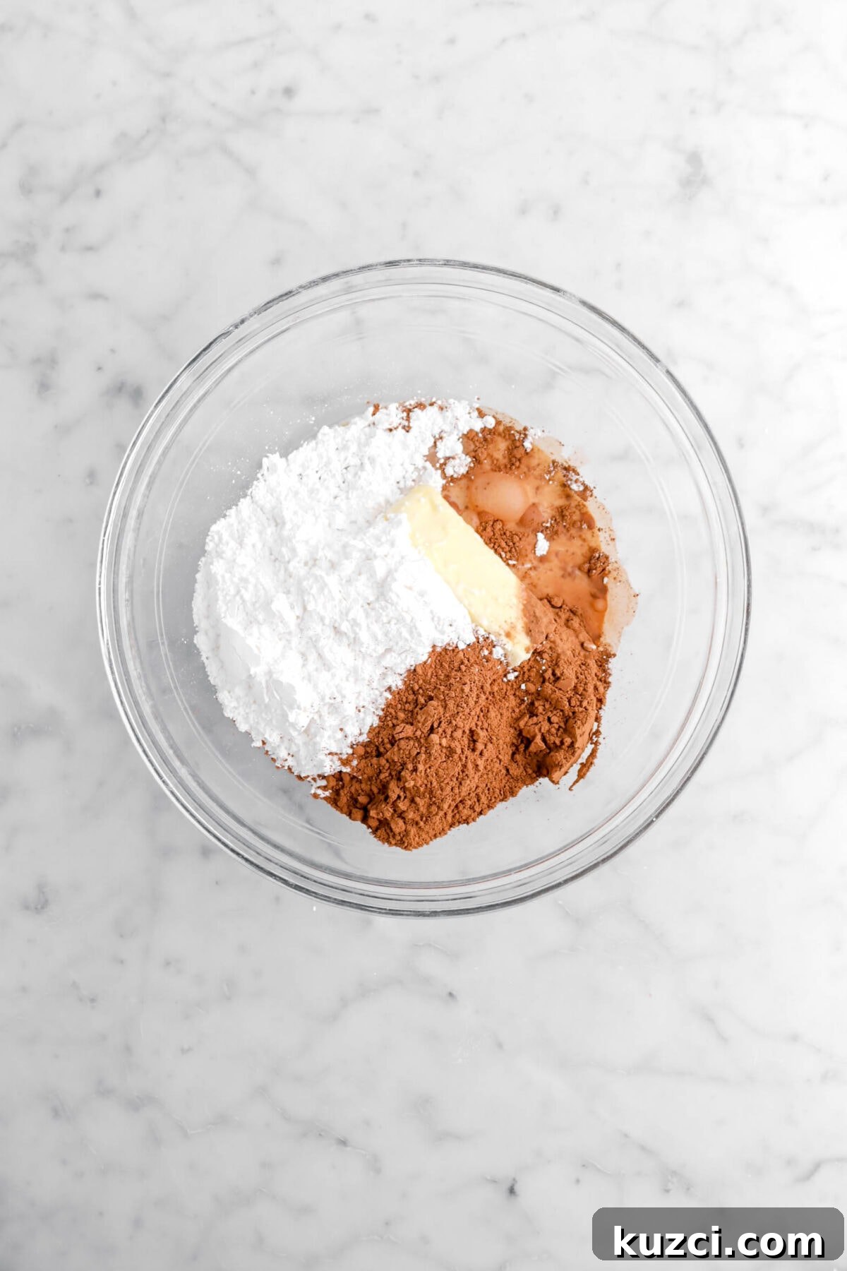 Chocolate Chip Cookie Cake with Chocolate Buttercream 21 powdered sugar, butter, cocoa powder, and milk in glass bowl.
