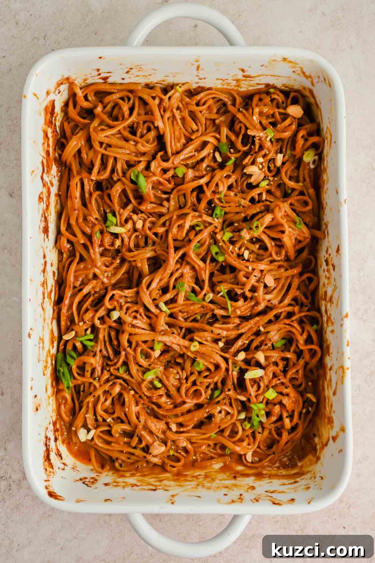 Spicy Peanut Noodles with Chili Garlic Sauce 9 spicy peanut noodles garnished with herbs in rectangular baking dish.