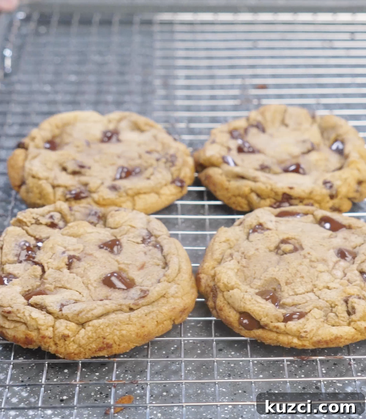 Freshly baked brown butter chocolate chip cookies cooling on a wire rack with golden edges and melted chocolate chunks.