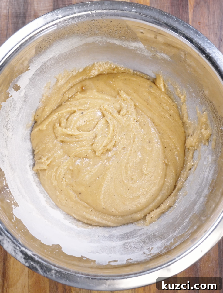 All-purpose flour, baking soda, and salt added to the cookie dough and gently folded in to prevent overmixing.