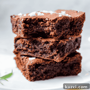 Quick Cannabis Chocolate Recipe for Homemade Edibles 10 A white plate with three cannabis brownies stacked on top, garnished with a cannabis leaf