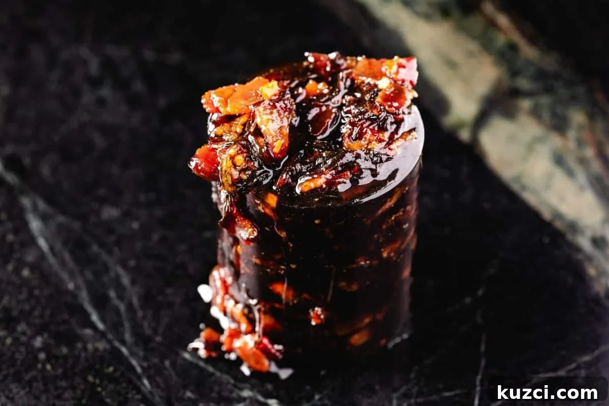 A glass mason jar overflowing with bacon jam.