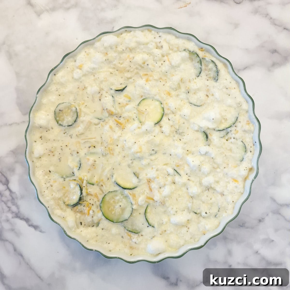 Crustless Cheesy Zucchini and Carrot Quiche 12 The quiche batter transferred into a 10-inch white baking dish.