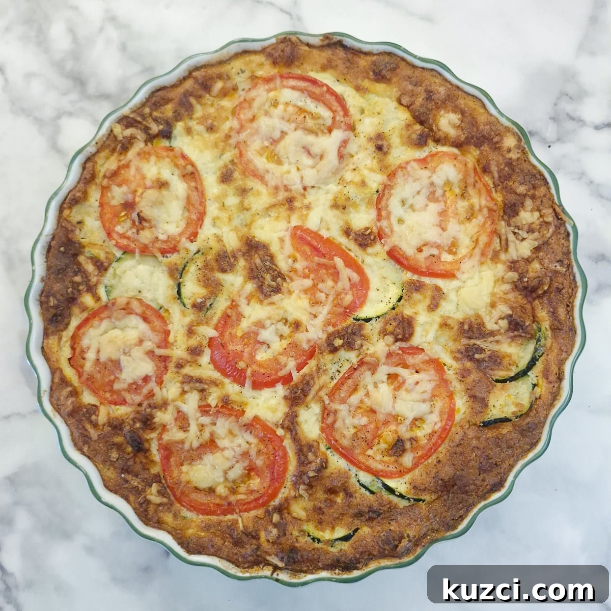 Crustless Cheesy Zucchini and Carrot Quiche 14 A baked courgette and carrot quiche in a round baking dish.