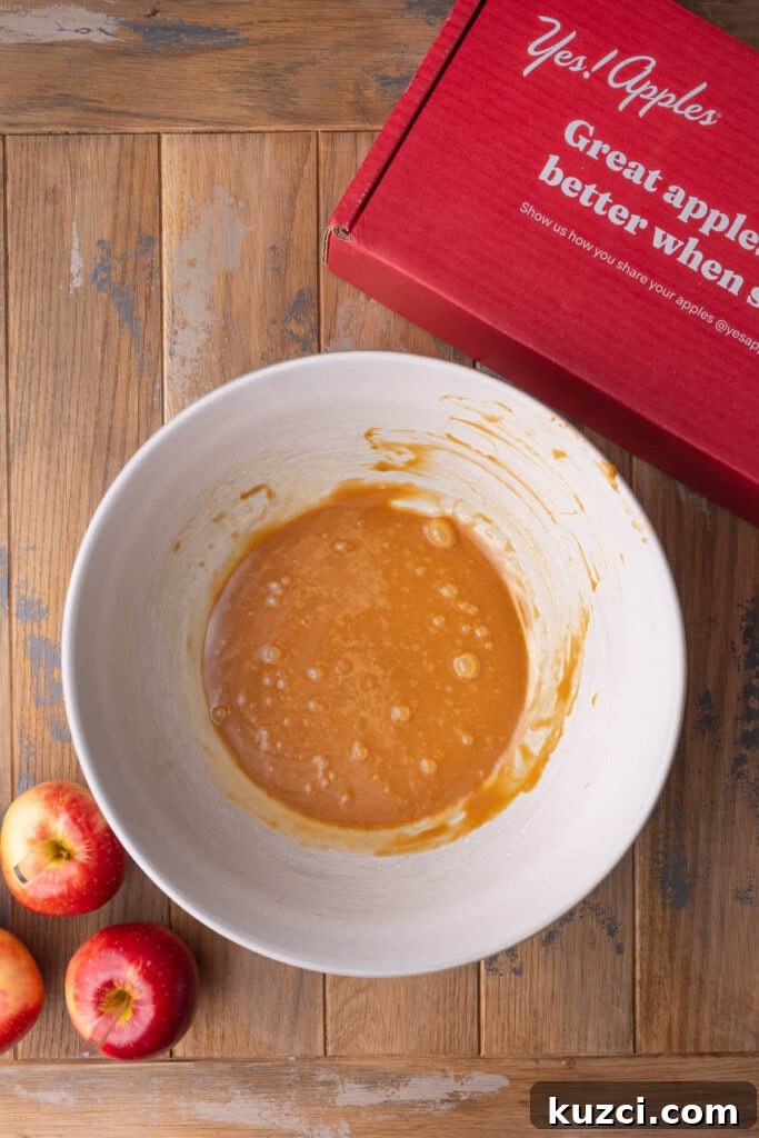 5-Ingredient Halloween Caramel Apples Recipe 7 Melted chewy caramels mixed with heavy cream in a large mixing bowl.