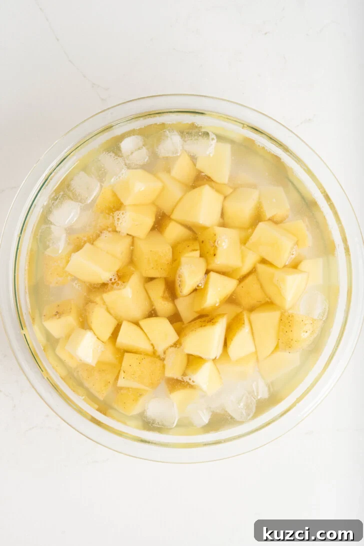 Patatas Bravas Recipe with Spicy Spanish Potatoes 4 Cubed potatoes in a bowl of ice water.