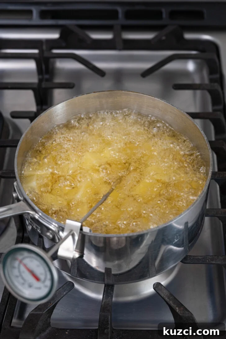 Patatas Bravas Recipe with Spicy Spanish Potatoes 8 Potatoes frying in oil.