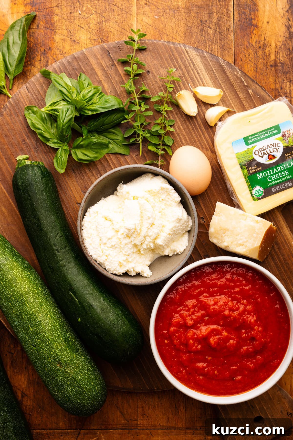 Zucchini Lasagna Recipe with Ricotta and Fresh Basil 3 Ingredients for zucchini lasagna arranged on a wooden board.