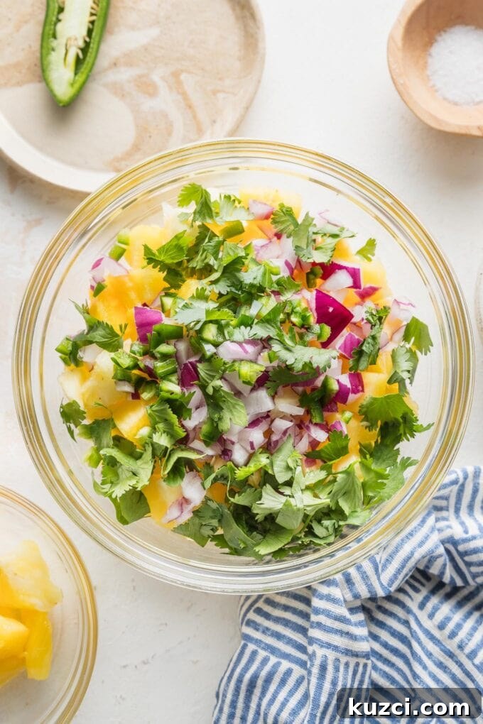 Fresh Pineapple Salsa with Jalapeño and Lime 4 Bowl full of pineapple, jalapeno, red onion, cilantro, lime juice, and salt, all ready to stir together into a fresh salsa.