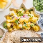 Fresh Pineapple Salsa with Jalapeño and Lime 7 Pineapple salsa served with tortilla chips in a pineapple shaped serving dish.