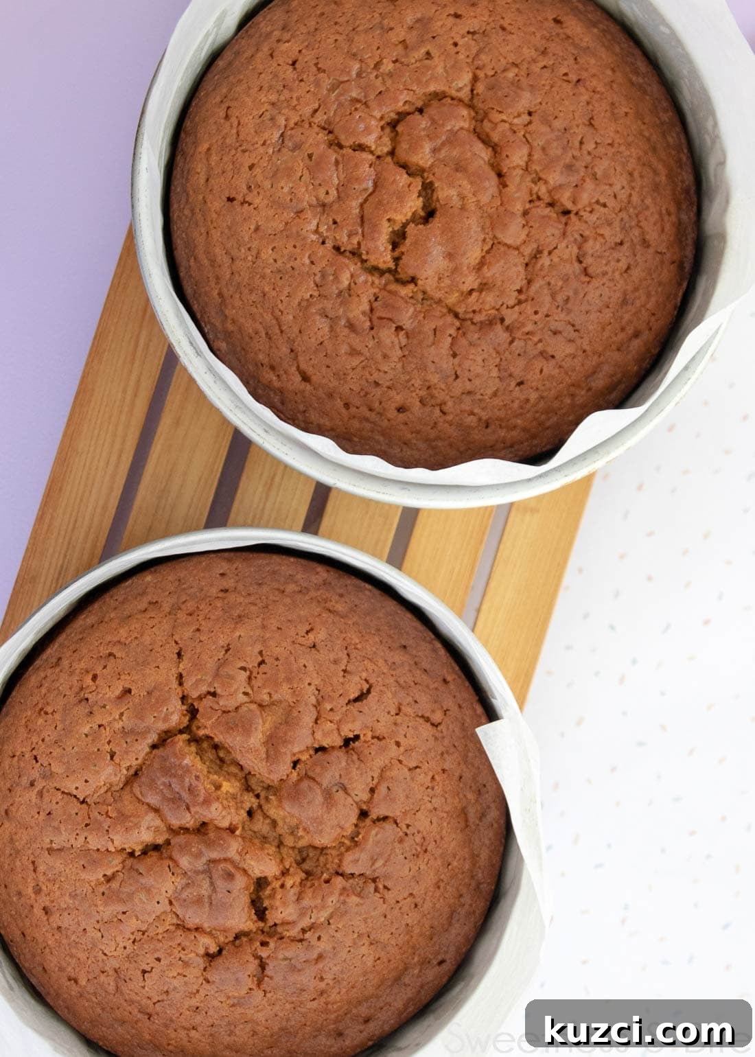 Caramel Mud Cake Recipe with Gluten Free Option 7 Two cakes in cake pans on a wooden cooling rack.