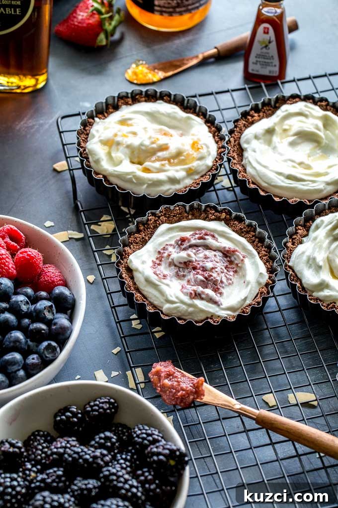 Tart shells filled with yogurt on a wire rack.