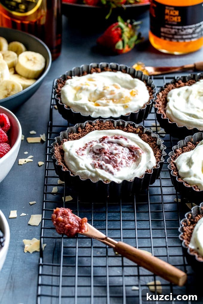 Up-close view of tart shells filled with yogurt and jam on a wire rack.