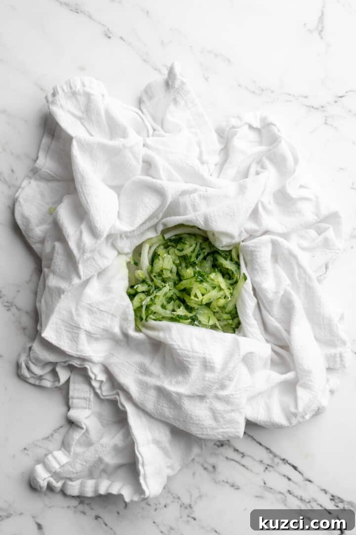Tzatziki: Greek Yogurt and Cucumber Sauce Recipe 5 Overhead view of grated cucumber in center of white kitchen towel