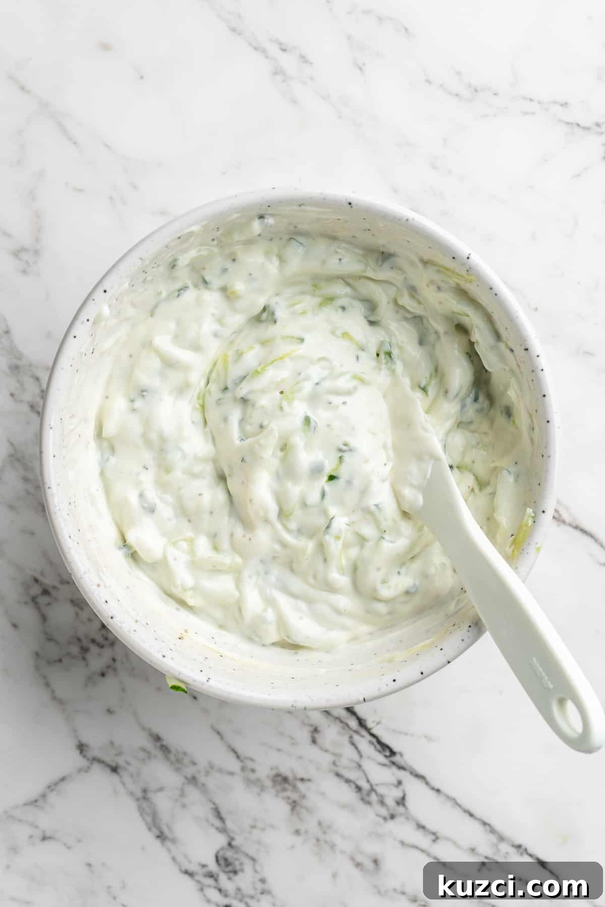 Tzatziki: Greek Yogurt and Cucumber Sauce Recipe 8 Overhead view of vegan tzatziki in bowl with spoon