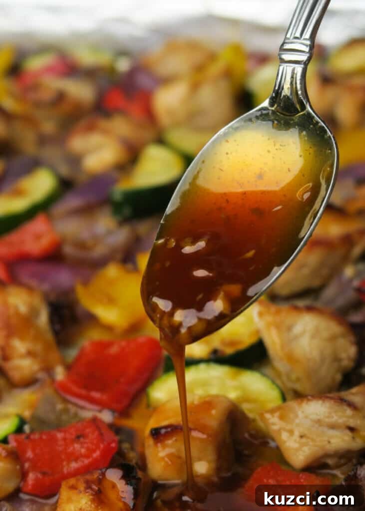 Sheet Pan Chicken and Vegetables: A Kabob Alternative 3 Honey garlic sauce being drizzled over Sheet Pan Chicken & Veggies