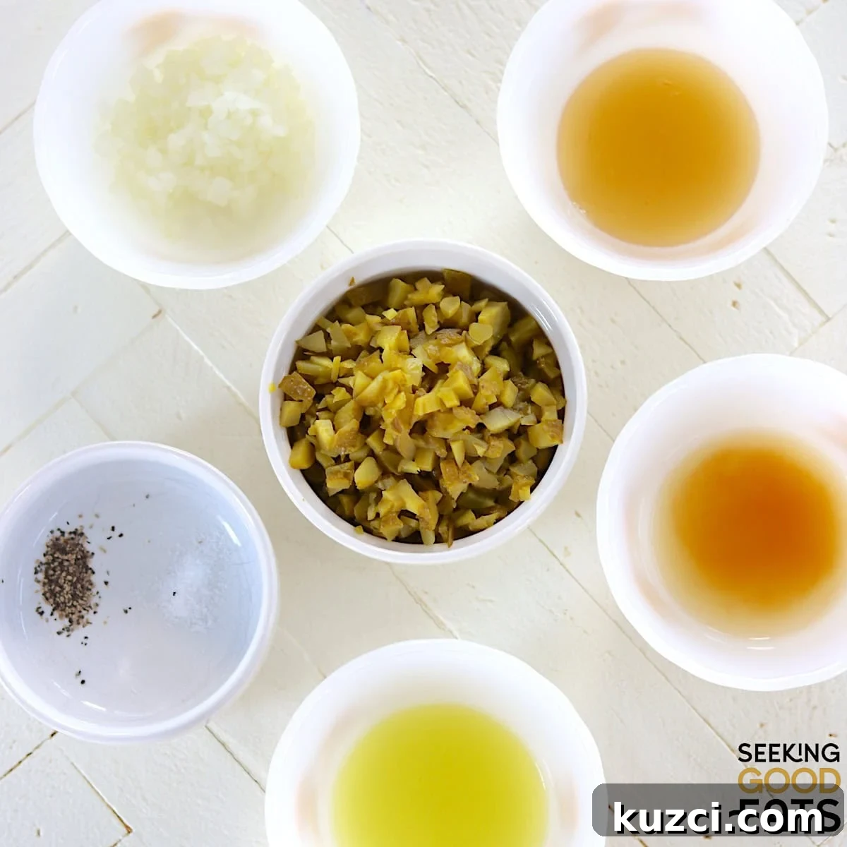 Ingredients needed to make dill pickle relish arranged on a white countertop.