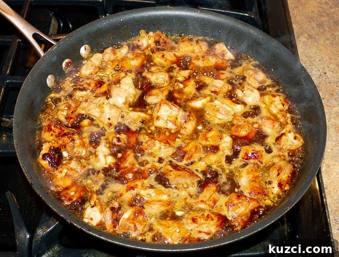 Sticky Orange Chicken Recipe with Tangy Citrus Glaze 6 Sticky Orange Chicken Recipe bubbling in a pan with sauce
