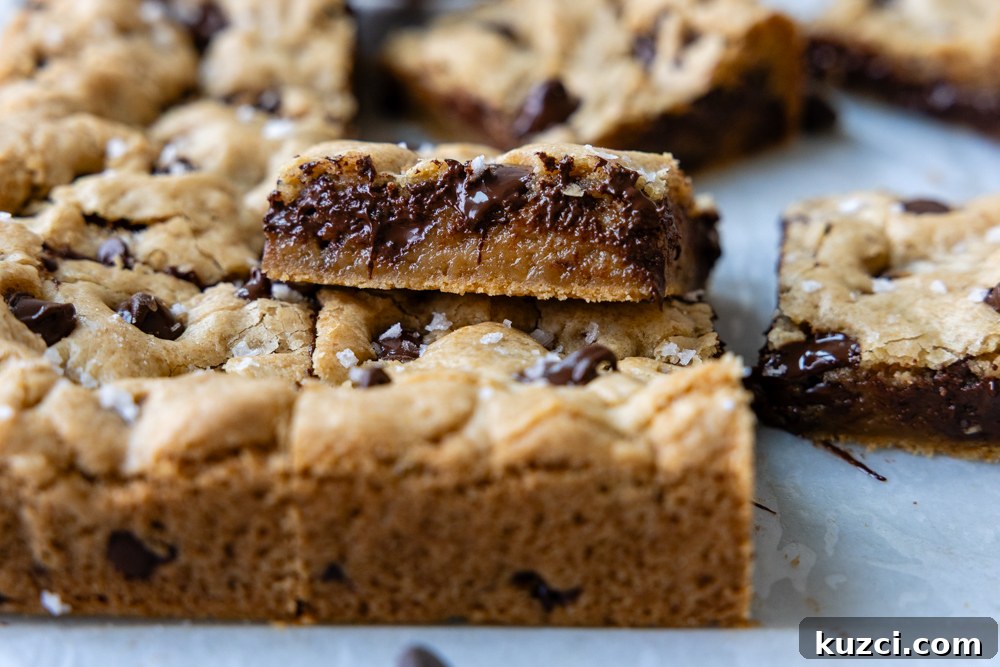 Stacked gluten-free chocolate chip cookie bars with melted chocolate chips.