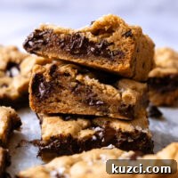 Stack of gluten-free chocolate chip cookie bars showing melted chocolate inside.