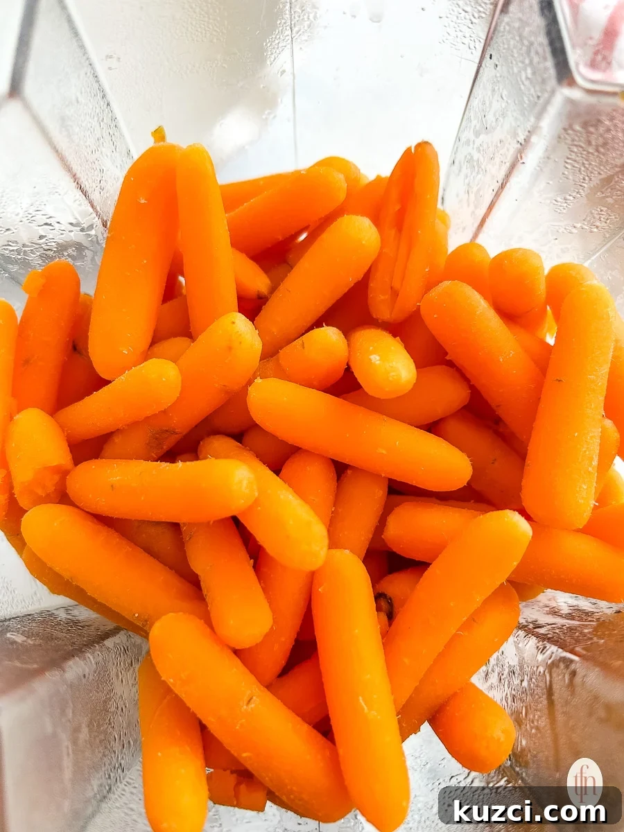 Baby carrots in a blender about to be blended.