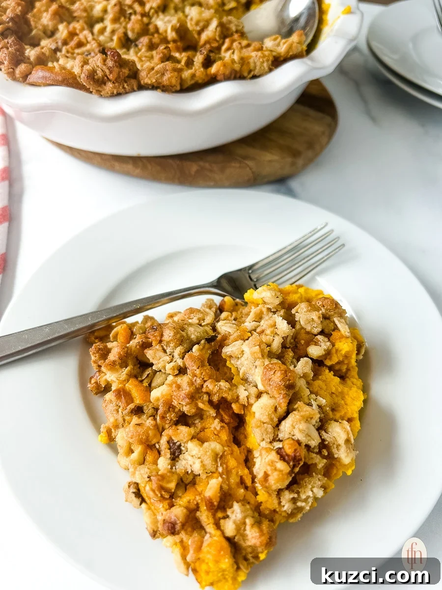 A white plate with a serving of carrot casserole with a fork.