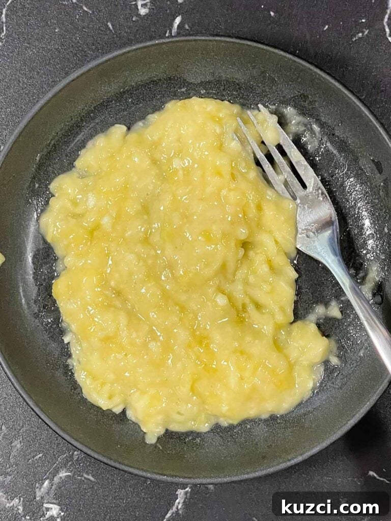 Fluffy Homemade Buttermilk Banana Pancakes 4 Mashed ripe banana in a bowl ready for banana pancake batter.