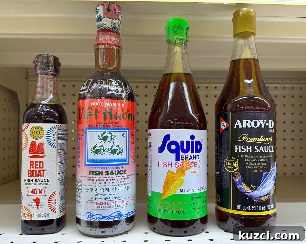 4 different bottles of fish sauce: red boat brand, three crabs brand, squid brand, and aroy-d premium brand.