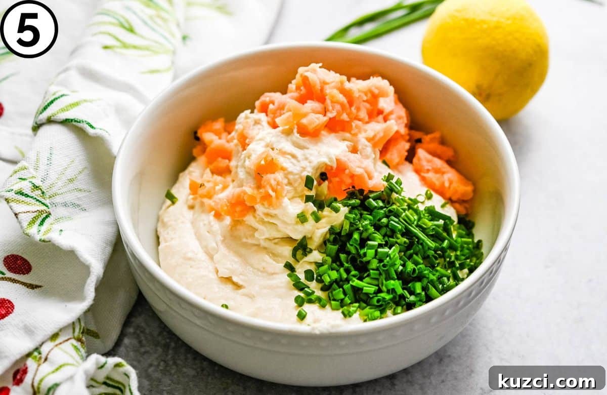 Smoked Salmon Cheese Ball with Dill and Capers 7 adding chopped salmon and chives to the blended goat cheese and salmon mixture.