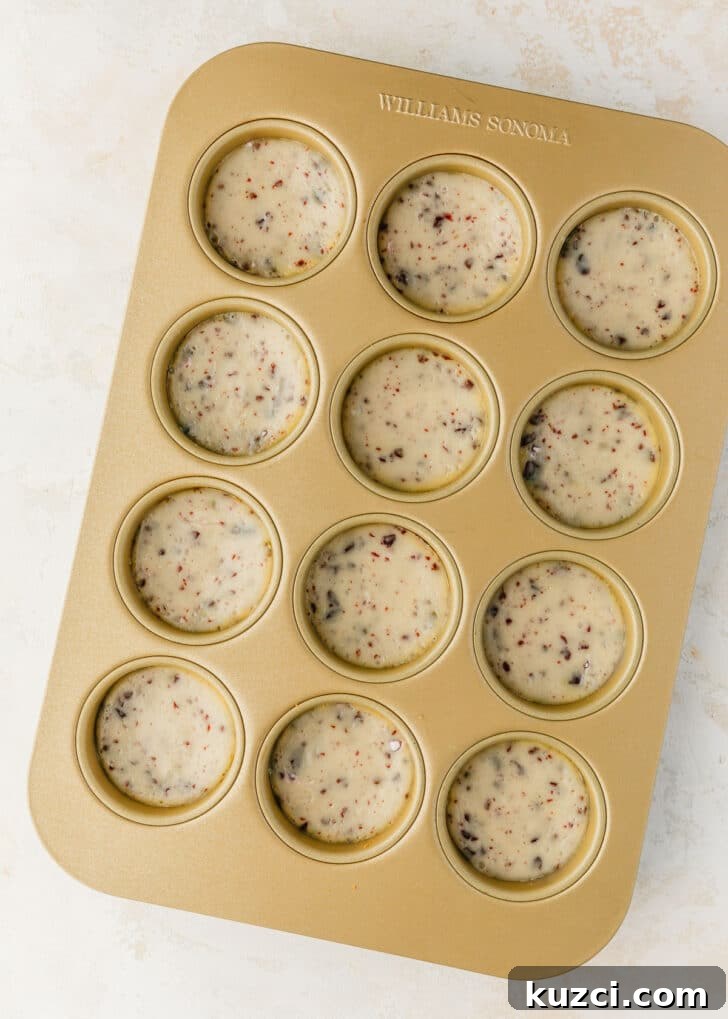 Mini Easter Egg Cheesecakes with Chocolate Ganache Recipe 12 A gold pan of mini egg cheesecakes on a tan table.